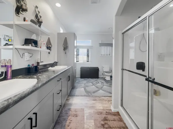 a spacious bathroom with a granite countertop sink a mirror and shower