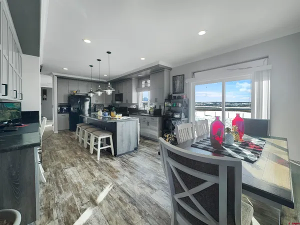a kitchen with stainless steel appliances kitchen island granite countertop a table and chairs