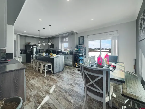 a kitchen with a dining table chairs and white appliances