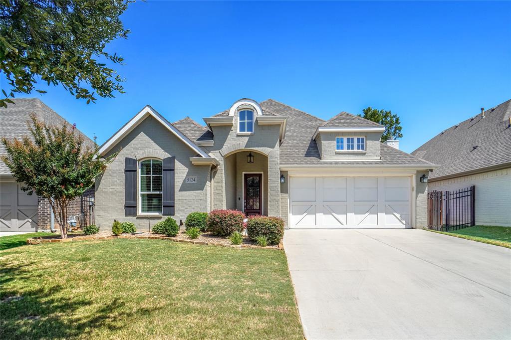 5124 Scott Road Fort Worth, TX 76114 - Photo 1 of 1 French country home with concrete driveway, brick siding, and roof with shingles