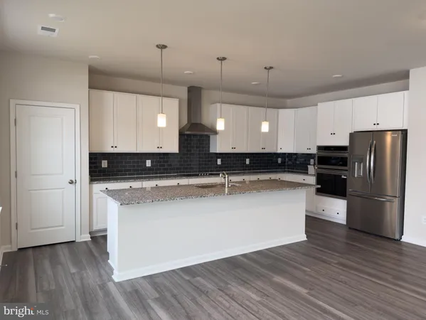a large kitchen with stainless steel appliances and a refrigerator