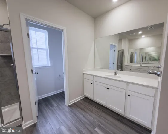 a spacious bathroom with a double vanity sink and a mirror
