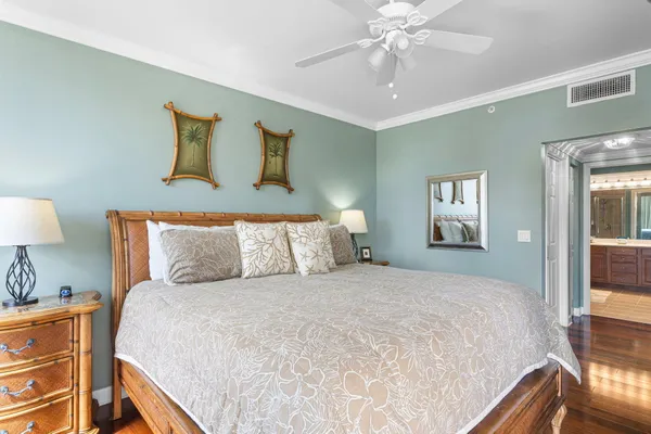 a bedroom with a large bed and a chandelier