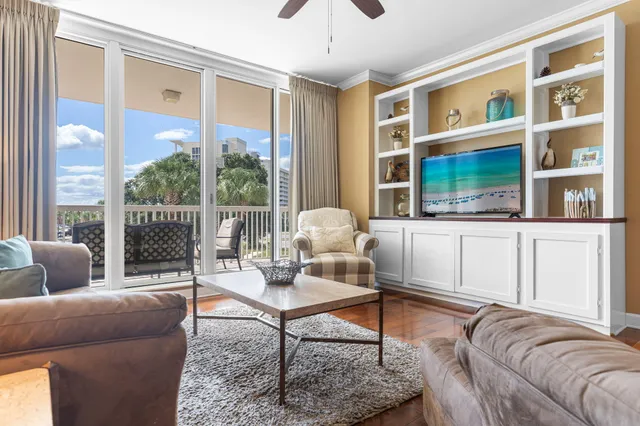 a living room with furniture wooden floor and a large window