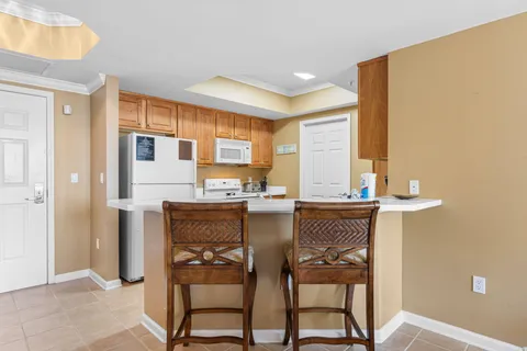 a kitchen with a table chairs refrigerator and cabinets