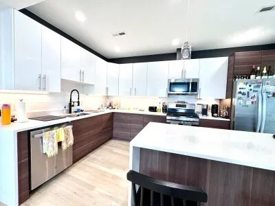 a large kitchen with stainless steel appliances wooden cabinets a sink and a stove