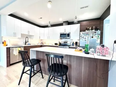 a kitchen with stainless steel appliances a table chairs refrigerator and a sink