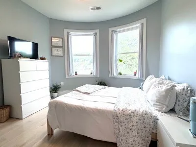 a bedroom with a bed and large windows