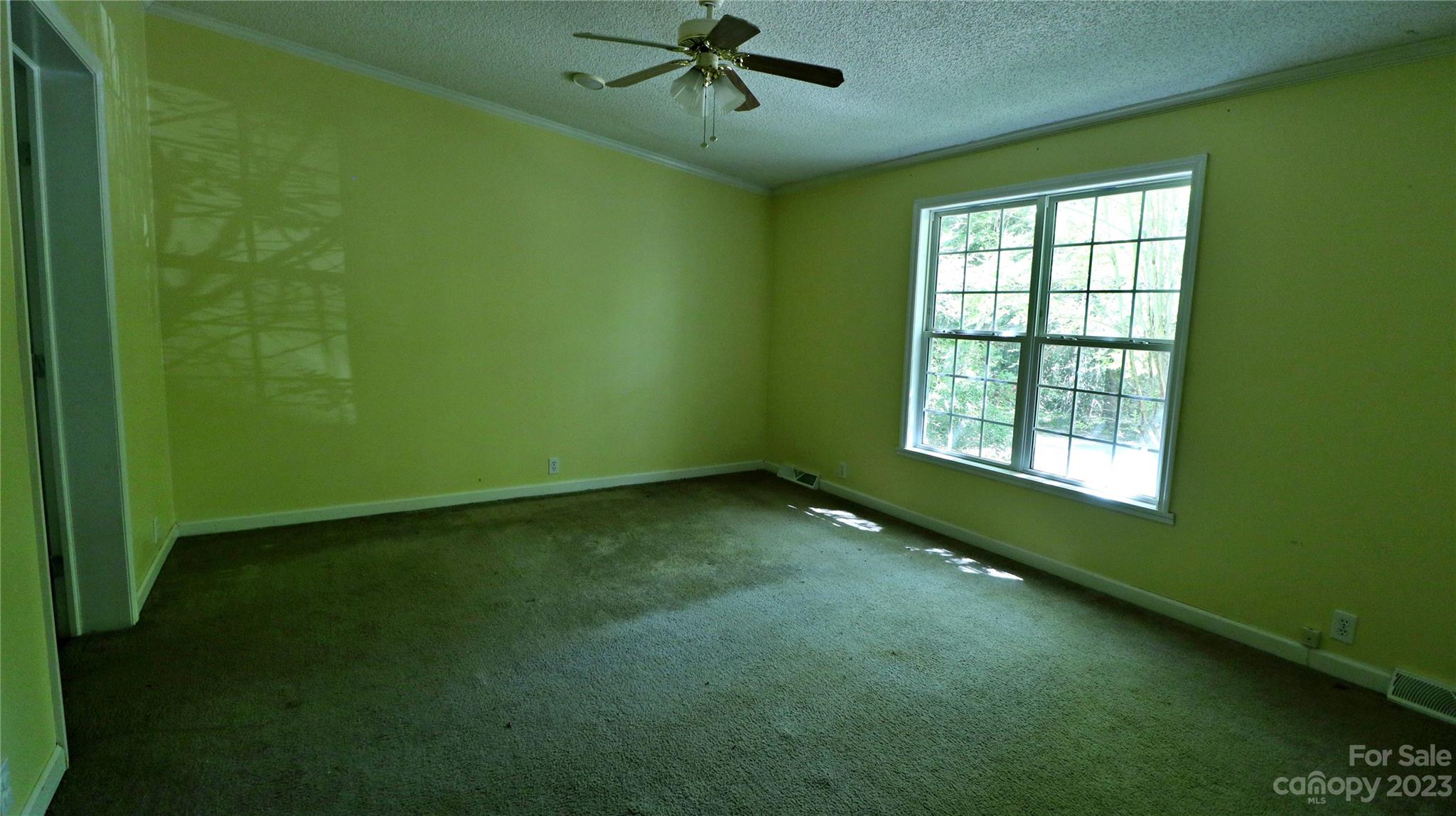 61 Sloan Street Old Fort, NC 28762 - Photo 22 of 38 a view of an empty room with a window and a ceiling fan