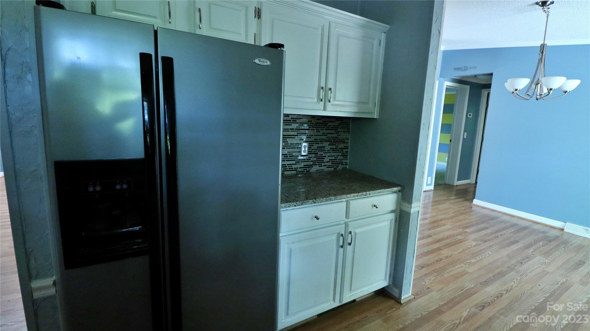 61 Sloan Street Old Fort, NC 28762 - Photo 8 of 38 a kitchen with white cabinets and wooden floor