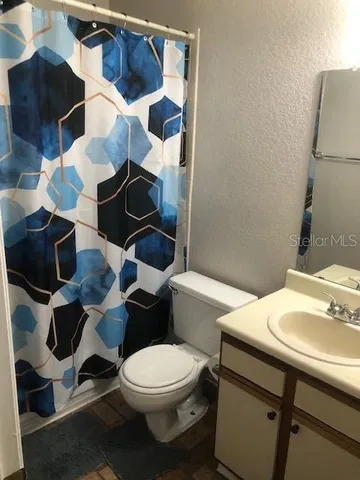 a white toilet sitting next to a bathroom sink and vanity