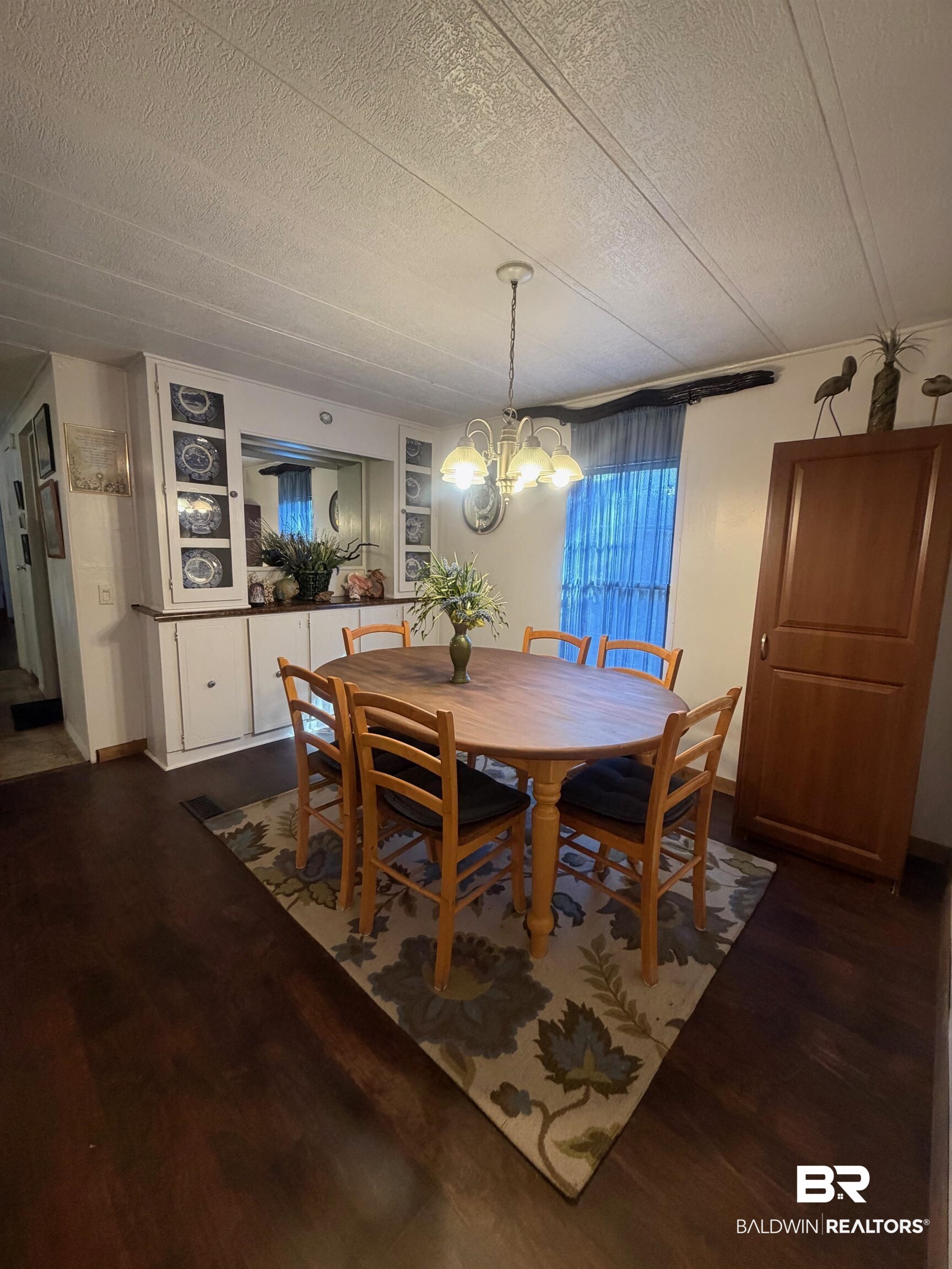 1430 Ridgewood Drive Lillian, AL 36549 - Photo 6 of 34 Dining room with dark wood-type flooring, a textured ceiling, and suspended lighting