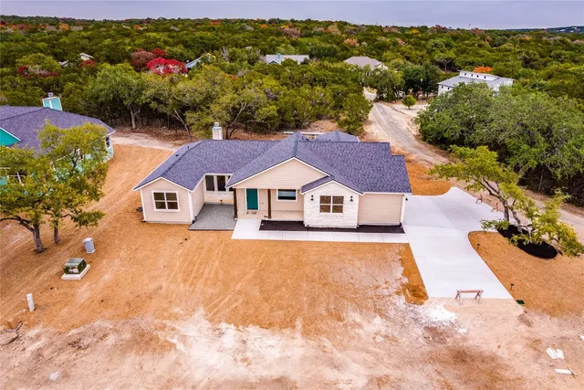 an aerial view of a house with swimming pool and mountains