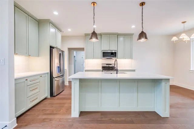 a kitchen with kitchen island a sink stainless steel appliances and cabinets