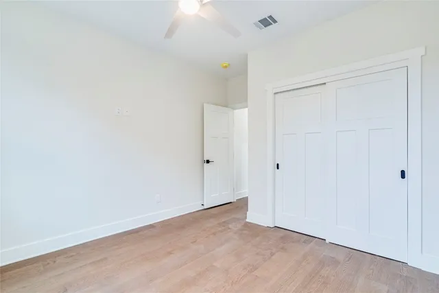 an empty room with a window and ceiling fan