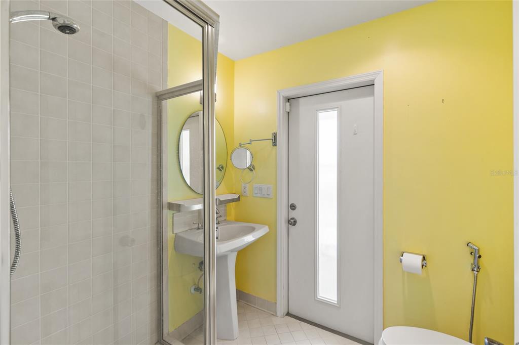 1009 Kings Court Venice, FL 34293 - Photo 17 of 25 a bathroom with a granite countertop shower a mirror and a toilet