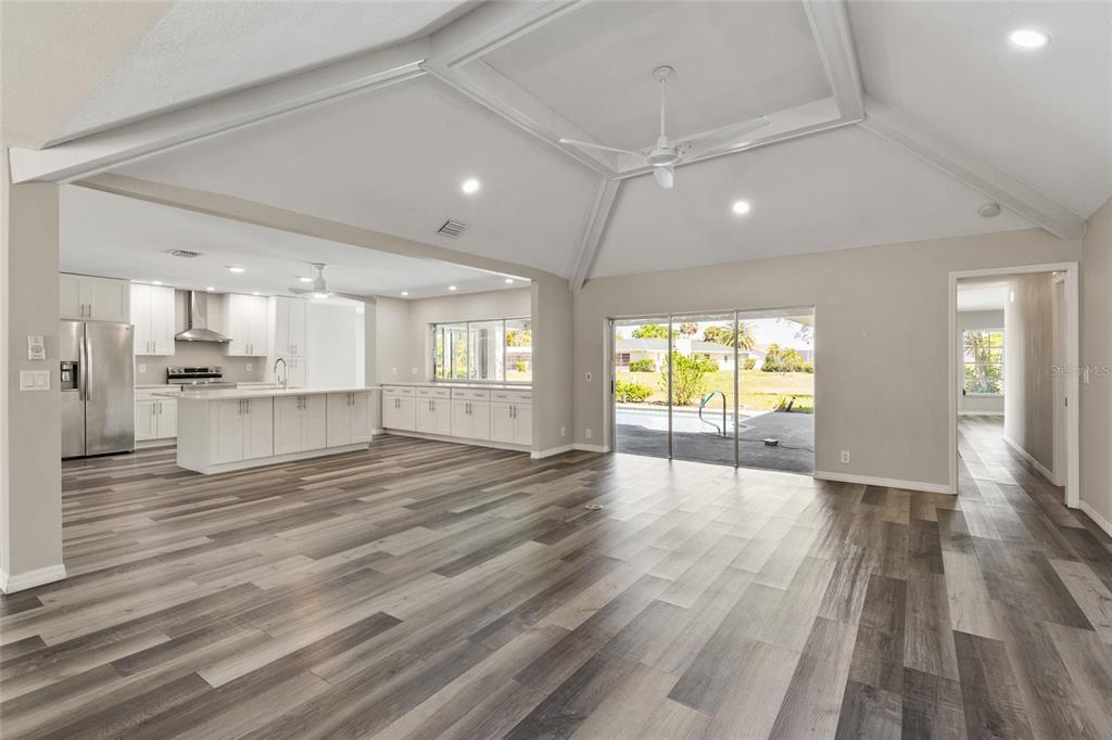 1009 Kings Court Venice, FL 34293 - Photo 5 of 25 a view of an empty room with wooden floor and a kitchen