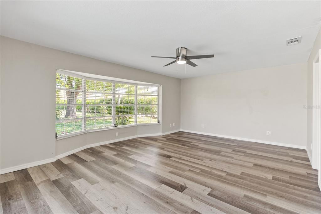 1009 Kings Court Venice, FL 34293 - Photo 8 of 25 a view of an empty room with wooden floor and a window