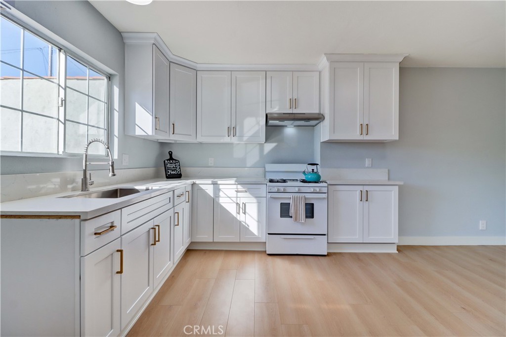 1101 Dawson Avenue Long Beach, CA 90804 - Photo 9 of 26 a kitchen with stainless steel appliances a white stove top oven sink and cabinets