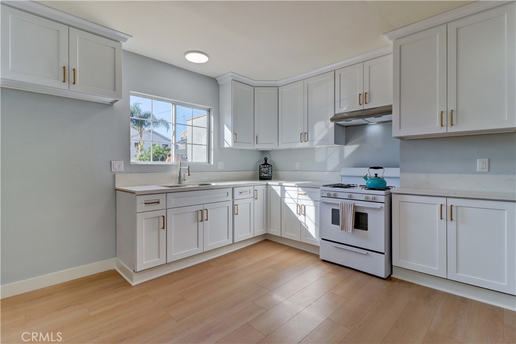 1101 Dawson Avenue Long Beach, CA 90804 - Photo 10 of 26 a white kitchen with granite countertop white cabinets and white appliances
