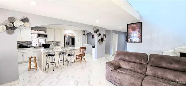 a living room with furniture a couch and a dining table with wooden floor