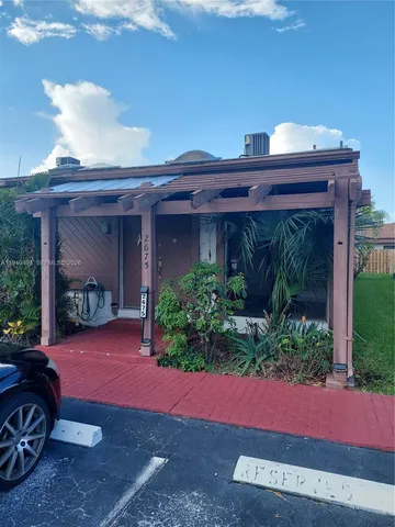a view of a house with a patio and a yard