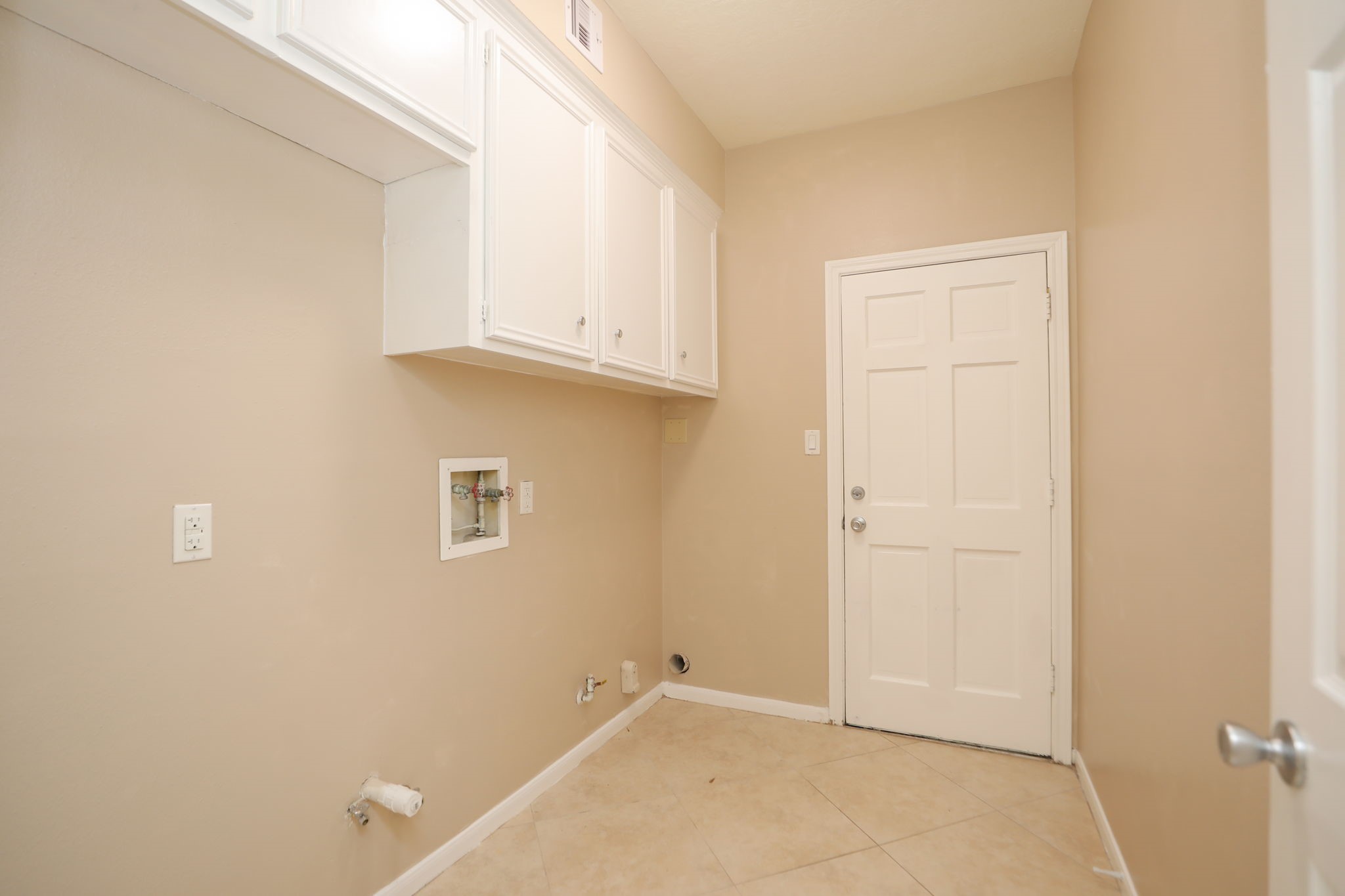 9311 Windrush Drive Spring, TX 77379 - Photo 20 of 50 Interior laundry room with room for a second refrigerator or freezer. The door in middle leads to the garage.