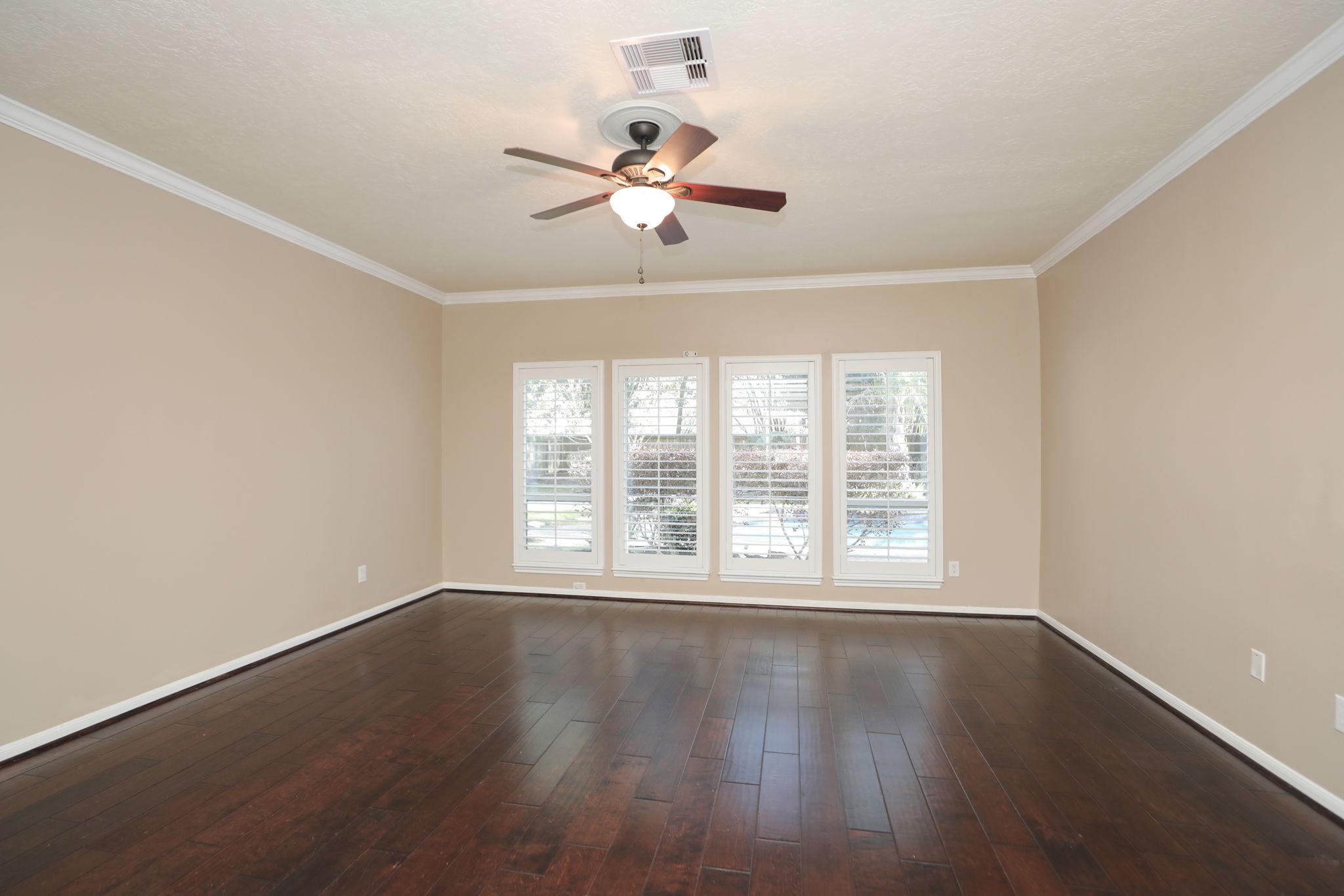9311 Windrush Drive Spring, TX 77379 - Photo 21 of 50 Huge downstairs primary bedroom with engineered wood flooring, crown molding and views toward the treed backyard. What a retreat!