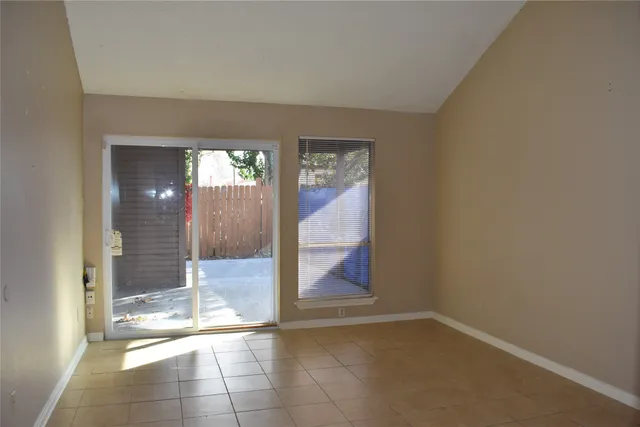 a view of a hallway with wooden floor and a glass door