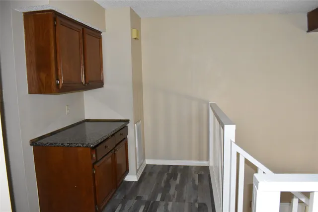 a utility room with wooden floor washer and dryer