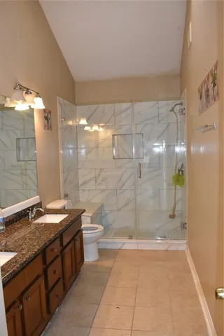 a bathroom with a granite countertop sink toilet and shower