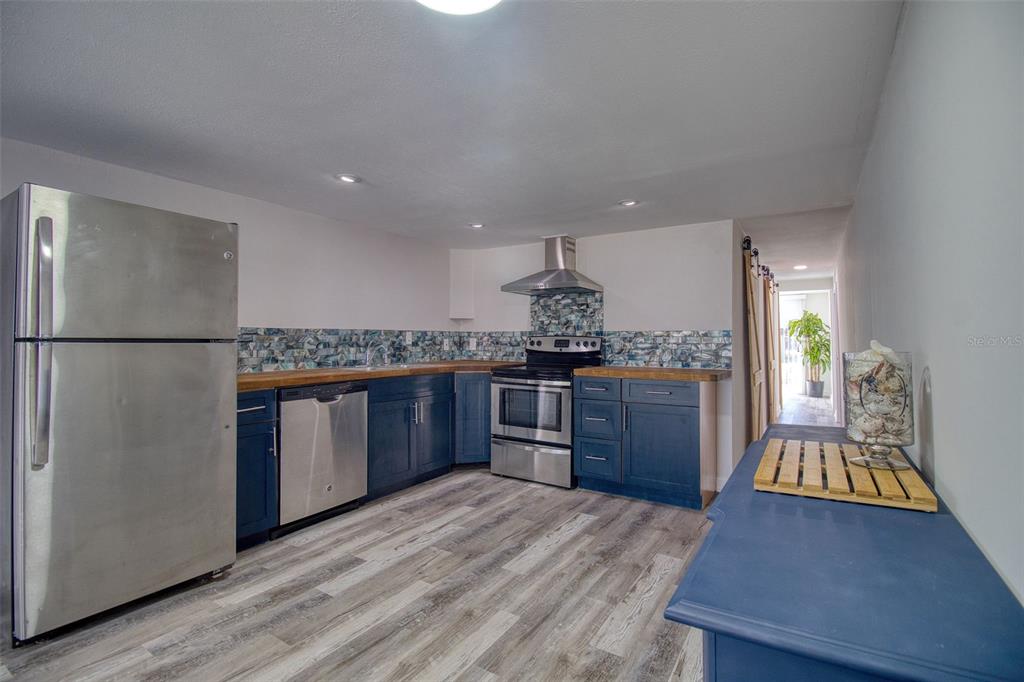 6820 Sea Ranch Drive Hudson, FL 34667 - Photo 7 of 29 a kitchen with stainless steel appliances granite countertop a refrigerator a stove and a wooden floors