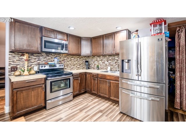 32907 Southwest Acacia Court, Unit 68 Cornelius, OR 97113 - Photo 4 of 15 a kitchen with stainless steel appliances a refrigerator sink and cabinets