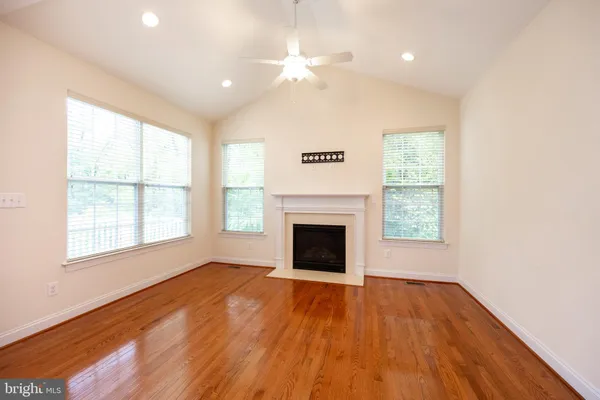 wooden floor fireplace and windows in an empty room