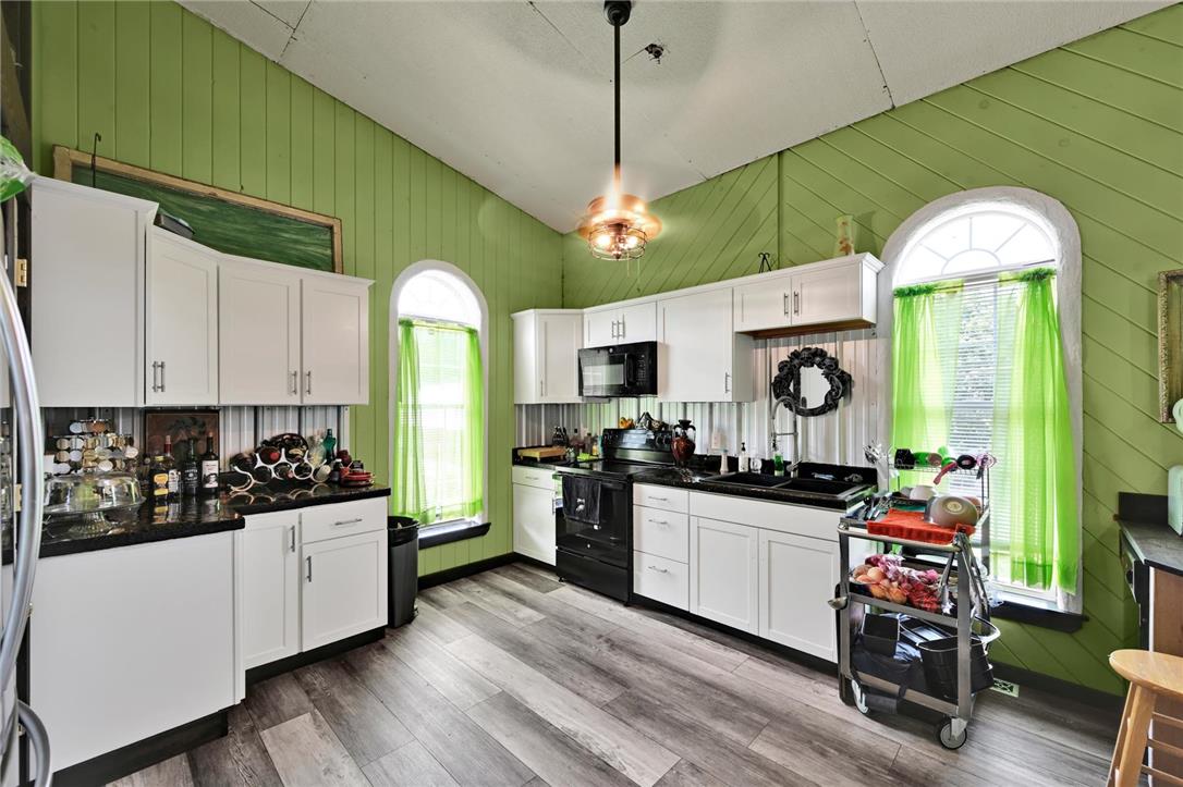 101 Conrad Road Fleetwood, PA 19522 - Photo 7 of 42 This cheerful kitchen features ample cabinetry, dark counters, and arched windows illuminating the workspace.