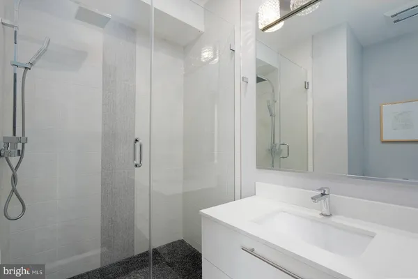 a bathroom with a shower sink and mirror
