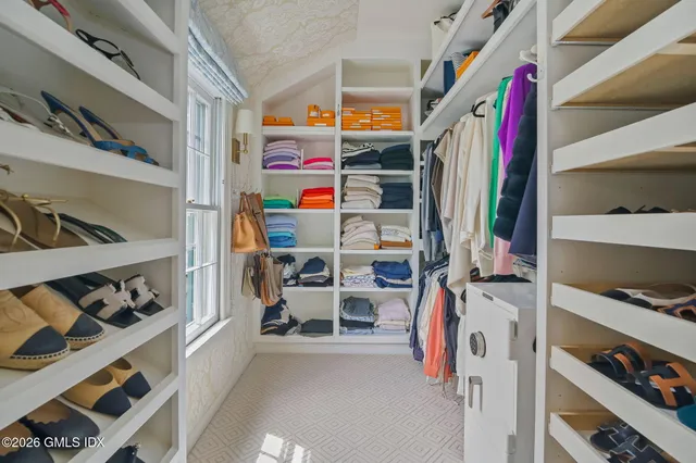 a view of walk in closet with clothes and shoes
