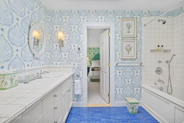 a spacious bathroom with a granite countertop sink and a mirror