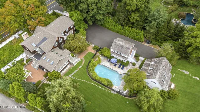 an aerial view of a house with a yard and lake view