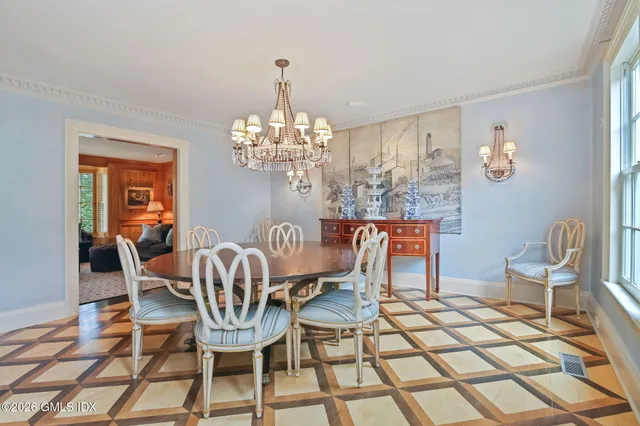 a dining room with furniture a chandelier and wooden floor