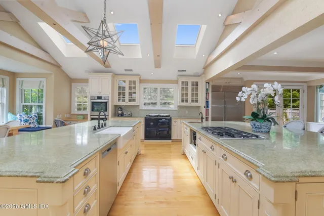a large kitchen with kitchen island a large counter space a sink appliances and cabinets