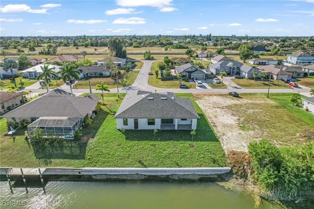 an aerial view of residential houses with outdoor space and lake view