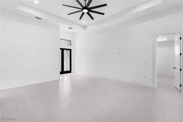an empty room with a ceiling fan and wooden floor