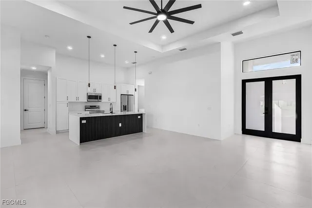 a living room with stainless steel appliances kitchen island furniture and a window