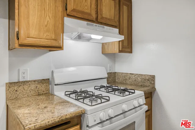 a white stove top oven sitting inside of a kitchen