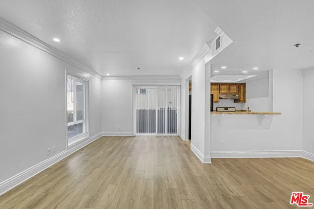 a view of a big room with wooden floor and a window