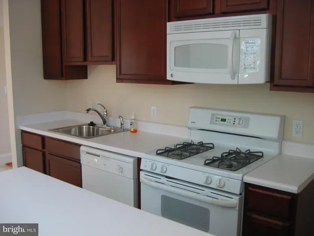 a kitchen with stainless steel appliances granite countertop a sink stove and microwave