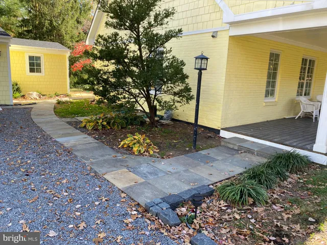 a view of a backyard with couches under an umbrella