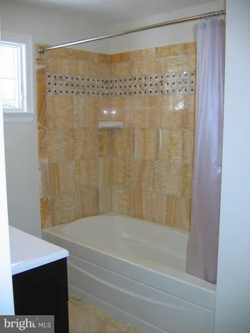 a bathroom with a shower and a bath tub