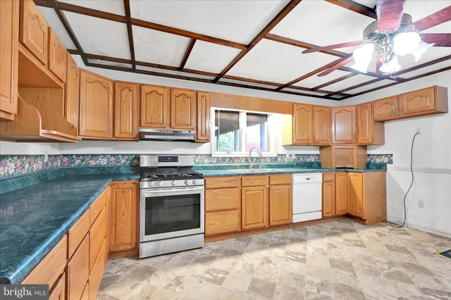 a kitchen with stainless steel appliances granite countertop a stove a refrigerator and a sink